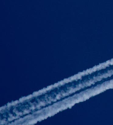 Blue sky with white flight trail of an airplane